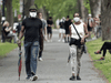 People wear face masks as they walk through a city park in Montreal. In a poll of Canadians, Quebec had the rosiest outlook toward the staying power of the pandemic.
