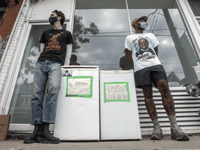 Julian Bentivegna, left, and Jalil Bokhari with a couple community fridges in front of Ten Restaurant on College Street in Toronto.