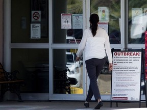 A woman enters the Good Samaritan Society Southgate Care Centre in Edmonton on Wednesday. Twenty-one deaths have now been linked to a COVID-19 outbreak at the care home.