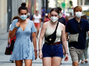 People wearing protective face masks walk on the street amid the coronavirus disease (COVID-19) outbreak in Madrid, Spain July 28, 2020.