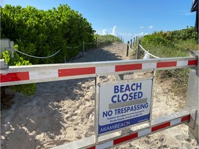 FILE - A sign informing about South Beach closure, to prevent the spread of the coronavirus disease (COVID-19), is seen ahead of the Fourth of July weekend, in Miami Beach, Florida, U.S., July 3, 2020.