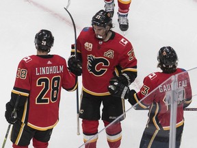 The Calgary Flames' Elias Lindholm, Matthew Tkachuk and Johnny Gaudreau celebrate a goal against the Edmonton Oilers during an NHL exhibition game at Rogers Place in Edmonton on Tuesday, July 28, 2020. /Jason Franson/The Canadian Press