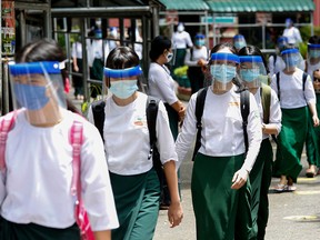 Students wear masks and face shields during the first day of reopening of high schools in Yangon, Myanmar, on July 21, 2020. A poll suggests that parents in Canada would like to see kids wear masks at school.