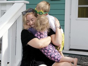 Melody Rodger has her hands full as she is seen playing with her young children on the porch of their SW Calgary home on Thursday, July 16, 2020.