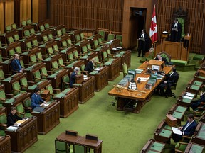 Prime Minister Justin Trudeau, Conservative Leader Andrew Scheer and a reduced number of members of Parliament wait for proceedings to begin in the House of Commons on April 11, 2020.