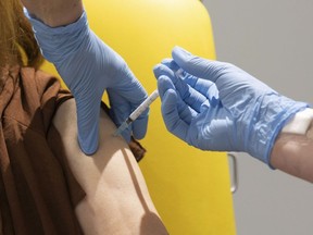 In this handout photo released by the University of Oxford a volunteer participates in the vaccine trial in Oxford, England on July 7, 2020. The Trudeau government is being pressed to approve funding for a made-in-Canada COVID-19 vaccine to lessen the risk Canadians will have to line up and wait on a foreign-made pandemic cure.