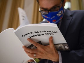 A copy of the federal government's Economic and Fiscal Snapshot 2020 is thumbed through as reporters take part in a media lock-up for the in Ottawa on Wednesday, July 8, 2020.