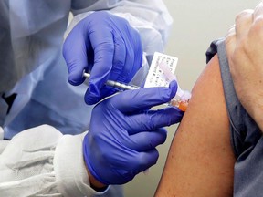 In this March 16, 2020, file photo, a subject receives a shot in the first-stage safety study clinical trial of a potential vaccine by Moderna for COVID-19, the disease caused by the new coronavirus, at the Kaiser Permanente Washington Health Research Institute in Seattle.