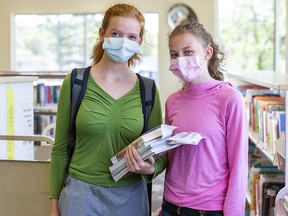 Grade 10 student Saydee Walker, left, and her sister Grayce pose for a photo during their visit to Louise Riley Library while wearing face-masks on Friday, August 14, 2020.