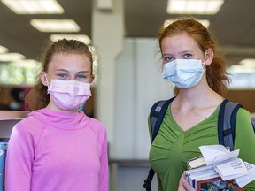 Grade 10 student Saydee Walker, left, and her sister Grayce pose for a photo during their visit to Louise Riley Library while wearing face-masks on Friday, August 14, 2020.