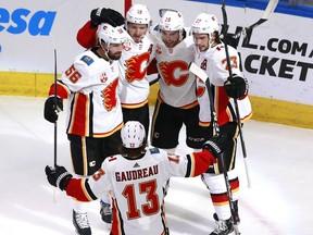 The Calgary Flames’ Elias Lindholm (28) is congratulated by teammates Erik Gustafsson (56) ,Matthew Tkachuk (19) ,Sean Monahan (23) and Johnny Gaudreau (13) after Lindholm scored during Game 3 of their play-in series against the Winnipeg Jets at Rogers Place in Edmonton on Aug 4, 2020.