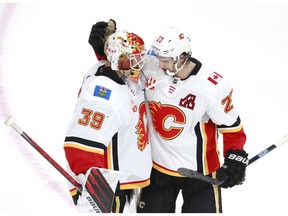 EDMONTON, ALBERTA - AUGUST 04: Cam Talbot #39 of the Calgary Flames celebrates the 6-2 win over the Winnipeg Jets with teammate Sean Monahan #23 after Game Three of the Western Conference Qualification Round prior to the 2020 NHL Stanley Cup Playoffs at Rogers Place on August 04, 2020 in Edmonton, Alberta.
