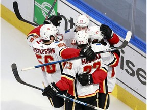 EDMONTON, ALBERTA - AUGUST 06: Dillon Dube #29 of the Calgary Flames celebrates with his teammates after scoring a goal on Connor Hellebuyck #37 of the Winnipeg Jets during the first period in Game Four of the Western Conference Qualification Round prior to the 2020 NHL Stanley Cup Playoffs at Rogers Place on August 06, 2020 in Edmonton, Alberta.