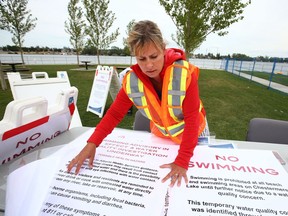 Town of Chestermere Recreation staff put up signage on Friday, August 14, 2020 notifying visitors of a swimming advisory due to health hazards at the lake east of Calgary. The beach areas and beaches will remain open at no charge during the investigative period, but access to the water from the beaches will be closed and signs posted advising of the potential health hazard. Jim Wells/Postmedia