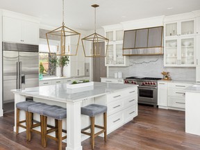 beautiful kitchen in new luxury home with island, pendant lights, and hardwood floors
