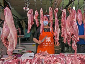 A vendor wearing a face mask works in her market stall in Wuhan, in Chinas central Hubei province on May 21, 2020.