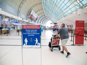 A man pushes a baggage cart through Toronto Pearson International Airport on June 23, 2020.