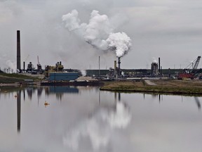 An oilsands extraction facility is reflected in a tailings pond near the city of Fort McMurray on June 1, 2014.