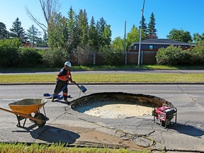 City of Calgary crews prepare to pump out a large sinkhole that appeared in the westbound lanes of Southland Drive between 14th Street and Elbow Dr. S.W. before making repairing it on Wednesday, August 5, 2020. Gavin Young/Postmedia