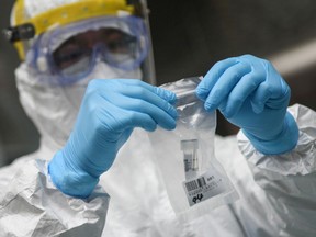 This photo taken on April 21, 2020 shows a medical staff member collecting a sample at a middle school as students receive nucleic acid testing for the COVID-19 coronavirus in Guangzhou in China's southern Guangdong province.