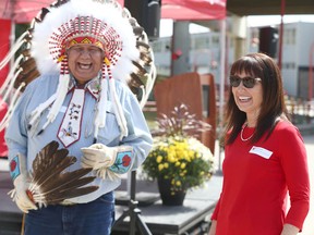 Dr. Reg Crowshoe, a Piikani Blackfoot elder, and United Way CEO Karen Young share a laugh during a Calgary Flames Foundation event on Wednesday. The United Way-Indigenous Communities Support program was one of 16 charities which received a part of $1 million in donations from the Flames Foundation online 50/50 program.