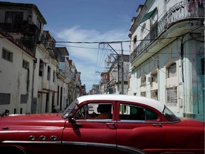People ride in a vintage taxi amid concerns about the spread of the coronavirus disease (COVID-19), in downtown Havana, Cuba, August 8, 2020.