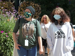 Katrin Bradshaw and Gianna Reid walk along Stephen Avenue S.W. wearing masks on a warm afternoon in August.