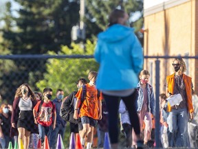Students wearing masks enter Westgate School guided by staff on their first day back on Tuesday, Sept. 1, 2020.