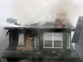 Calgary firefighters fight a fire that destroyed two homes and damaged two others on Evanston Drive N.W. on Tuesday, September 8, 2020.