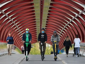 Kyle Erickson, left with Lime, Rashaan Stump with Bird and Derrick Jewlal with Roll e-scooters ride across the Peace Bridge in Eau Claire on Wednesday, September 16, 2020. The City of Calgary is asking for online input as the shared e-scooter pilot program comes to an end.