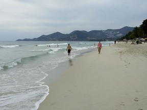 Tourists walk in Chaweng Beach in Koh Samui, Thailand.