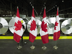 Canadian flags stand in front of rolls of coated steel at Stelco in Hamilton before a visit by Chrystia Freeland, then the foreign affairs minister, in 2018.