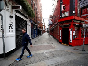 FILE PHOTO: A man walks past a pub in Dublin on St. Patrick's Day as public events were cancelled as the number of coronavirus cases grow around the world, in Dublin, Ireland, March 17, 2020. REUTERS/Jason Cairnduff/File Photo ORG XMIT: FW1