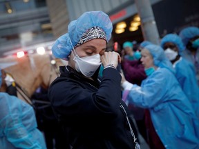 We will get through this pandemic together, says columnist George Brookman. A nurse wipes away tears as she stands outside NYU Langone Medical Center on 1st Avenue in Manhattan as New York police came to cheer and thank health-care workers in New York City, April 16, 2020.