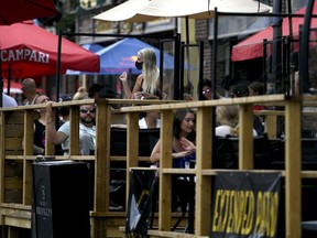 A server wears a mask as she works among the plexiglass dividers at a bar's outdoor patio in the Byward Market in Ottawa, on July 12, 2020, in the midst of the COVID-19 pandemic. As the weather gets cooler and COVID-19 cases start to surge again, more and more Canadians are looking to extend patio season by adding a heater to their outdoor space.The demand for patio heaters has risen so much that retailers have been struggling to keep them in stock, according to the Retail Council Canada. Moves multiple wires; guard against duplication.