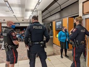 Police are seen at a Calgary airport gate before a red-eye flight to Toronto early on Sept. 8, 2020. A family of four was removed from the flight after their two young children were not wearing masks, the family says. The flight was ultimately cancelled.