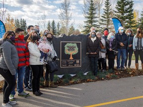 Homicide victim family members gather around the dedication plaque at the opening of the new Quinterra Legacy Garden at South Glenmore Park in Calgary, Ab., on Thursday October 15, 2020. The Quinterra Legacy Garden honours the lives of Lawrence Hong, Josh Hunter, Kaitlan (Kaiti) Perras, Jordan Segura and Zackariah Rathwell who were killed in 2014.