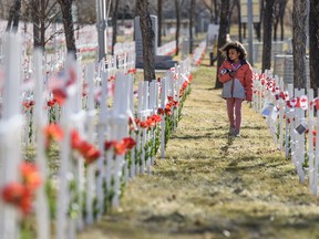 Eight-year-old Anika walks among the thousands of crosses that are erected in Field of Crosses along  Memorial Drive in Calgary to pay tribute to the fallen soldiers of Southern Alberta on Friday, October 30, 2020.