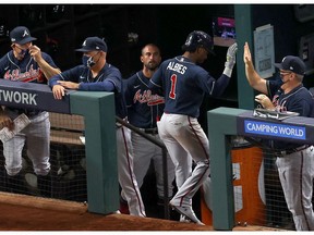 ARLINGTON, TEXAS - OCTOBER 13:  Ozzie Albies #1 of the Atlanta Braves is congratulated by his teammates after hitting a solo home run against the Los Angeles Dodgers during the ninth inning in Game Two of the National League Championship Series at Globe Life Field on October 13, 2020 in Arlington, Texas.