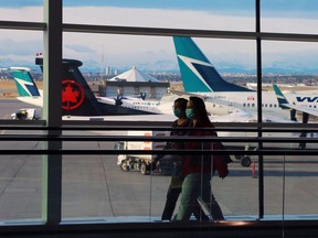 Travellers more through Calgary International Airport with aircraft in the background on Tuesday, October 27, 2020.