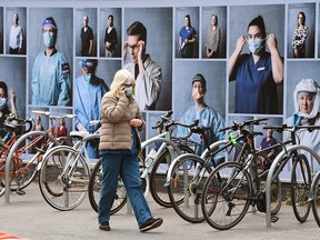 A woman walks past a display of photos outside the Royal Melbourne Hospital on October 20, 2020, to thank healthcare workers.