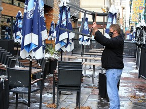 Milestones employee Rob Ahara stacks up patio furniture as the restaurant packed up its large Stephen Avenue Mall patio for the season on Wednesday, Oct. 14, 2020.