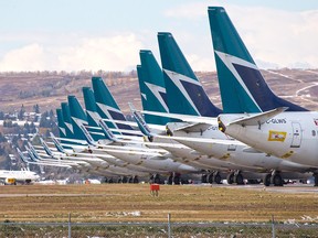 Sidelined WestJet Boeing 737 jets sit parked on an unused runway at Calgary International Airport on Oct. 14, 2020.