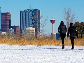 Calgarians walk in River Park with the downtown Calgary skyline as a backdrop on Tuesday, October 20, 2020.