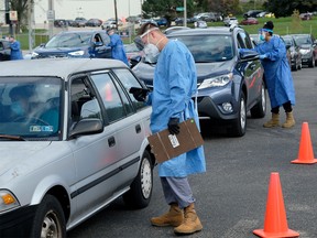 FILE PHOTO: People line up in their vehicles to undergo COVID-19 tests, distributed by the Wisconsin National Guard at the United Migrant Opportunity Services center, as cases spread in the Midwest, in Milwaukee, Wisconsin, U.S., October 2, 2020.