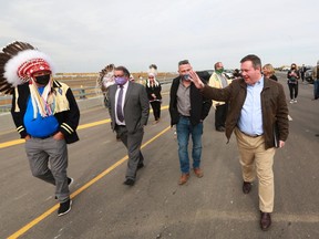 Tsuut'ina Chief Roy Whitney, left, Calgary Mayor Naheed Nenshi and Alberta Premier Jason Kenney, right, walk together at the opening of the Tsuut'ina Trail section of the southwest Calgary ring road on Thursday, October 1, 2020.