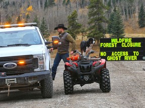 An Alberta Forestry officer chats with a local rancher at the closed road into the Ghost River Recreation Area after the status of the Devil's Head wildfire was changed to out of control on Tuesday, October 6, 2020. Crews now say the spread of the fire has slowed.