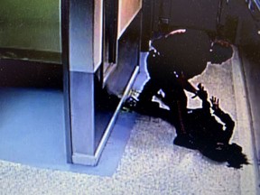 In this still from a court exhibit video, Calgary police Const. Alexander Dunn is shown after slamming a black female suspect, Dalia Kafi, face first into the floor.