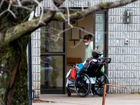 A woman opens the door to a person in a wheelchair at Pinecrest Nursing Home after several residents died and dozens of staff were sickened due to coronavirus disease (COVID-19), in Bobcaygeon, Ontario, Canada March 30, 2020.