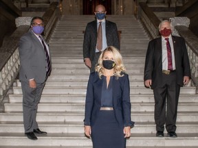 Four mayors, front row, Tara Veer of Red Deer, back row, left, Naheed Nenshi of Calgary, Don Scott of the Regional Municipality of Wood Buffalo and Chris Spearman of Lethbridge, stand on the steps of the Alberta legislature during a mission to the provincial government to oppose the centralization of EMS in Alberta.